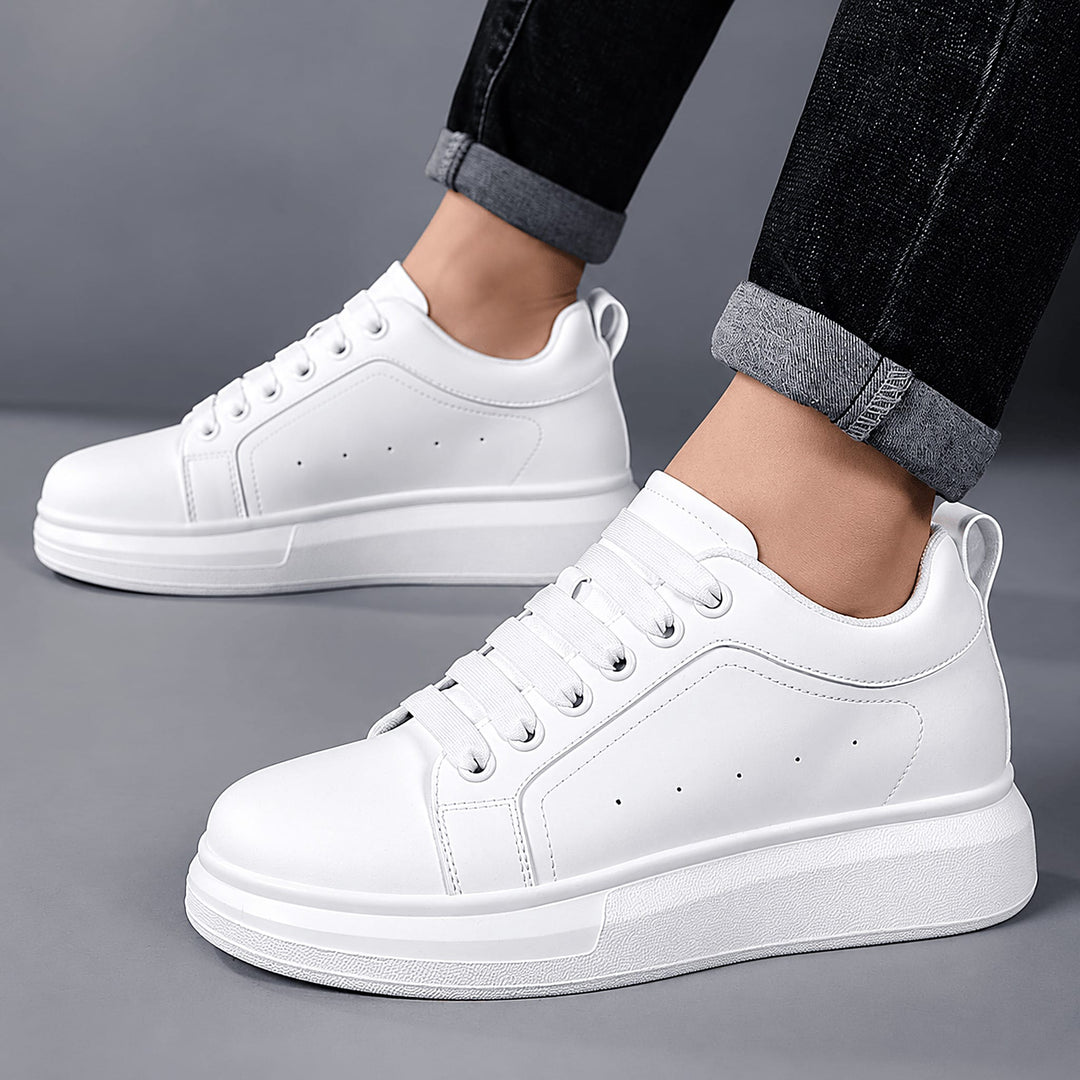 Man wearing Ratio Lumen white platform sneakers with cuffed dark jeans