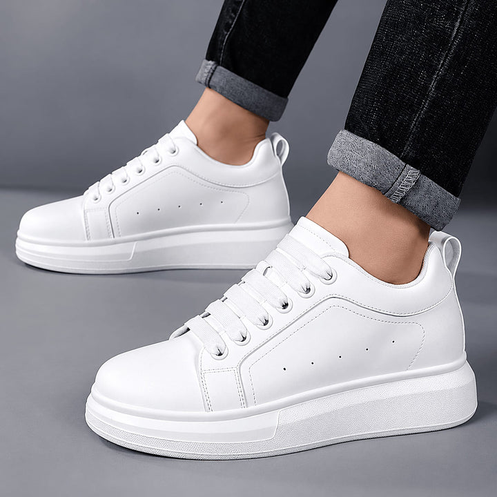 Man wearing Ratio Lumen white platform sneakers with cuffed dark jeans