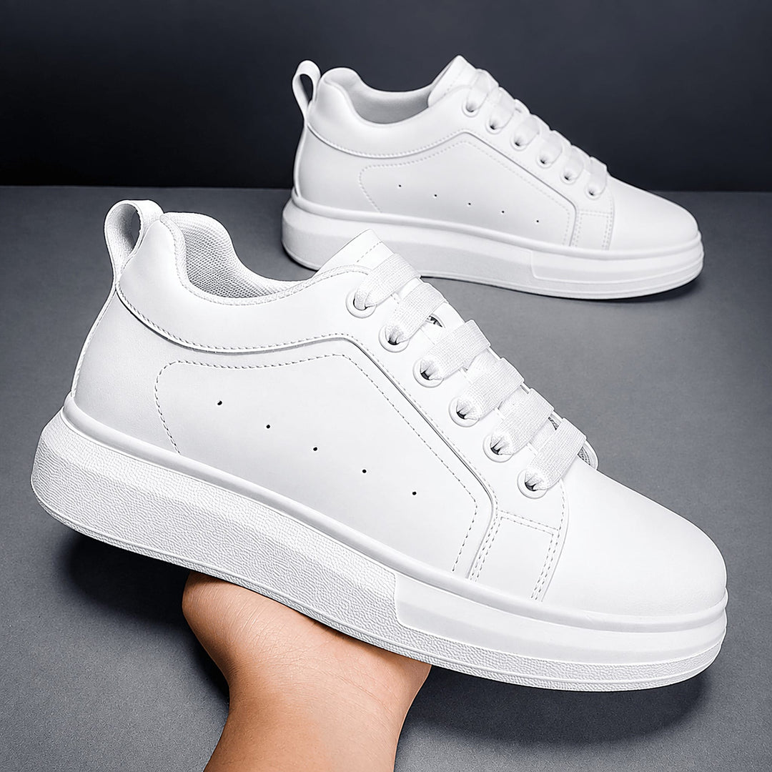 Pair of Ratio Lumen white platform sneakers held in hand