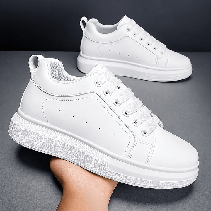 Pair of Ratio Lumen white platform sneakers held in hand